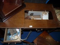 A sewing machine table with Singer sewing machine in compartment a/f.