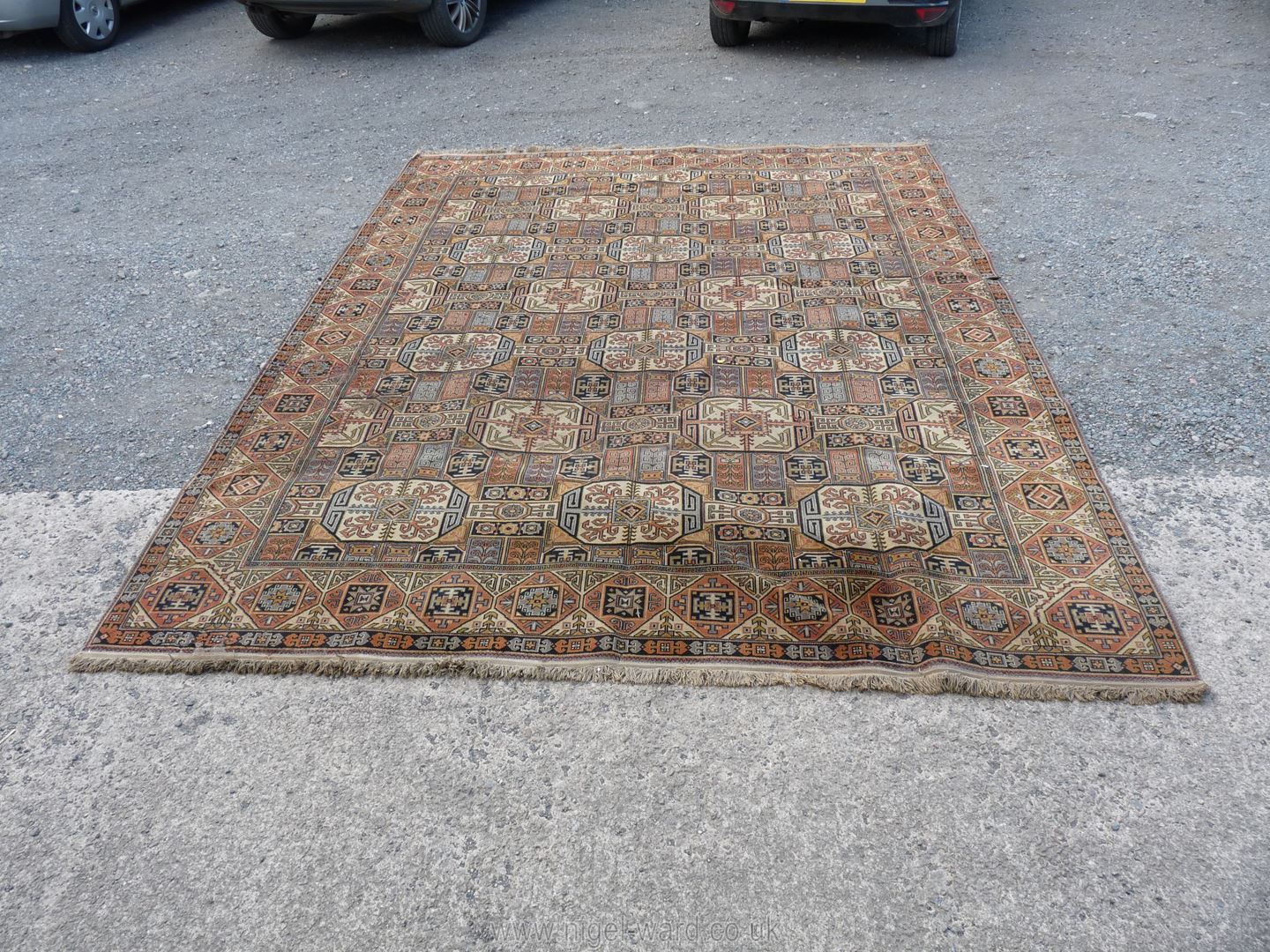 A large geometric brown, black and cream ground, bordered, patterned and fringed Carpet,