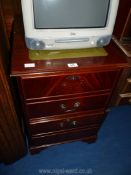 A dark wood filinf cabinet with green leather insert to top.