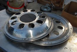 Three stainless steel commercial vehicle wheel trims.