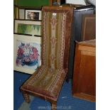 A tall backed nursing chair with tapestry seat.