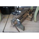 A large carpenter's vice and an old cane fishing rod.