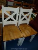 A pair of white painted dining chairs.