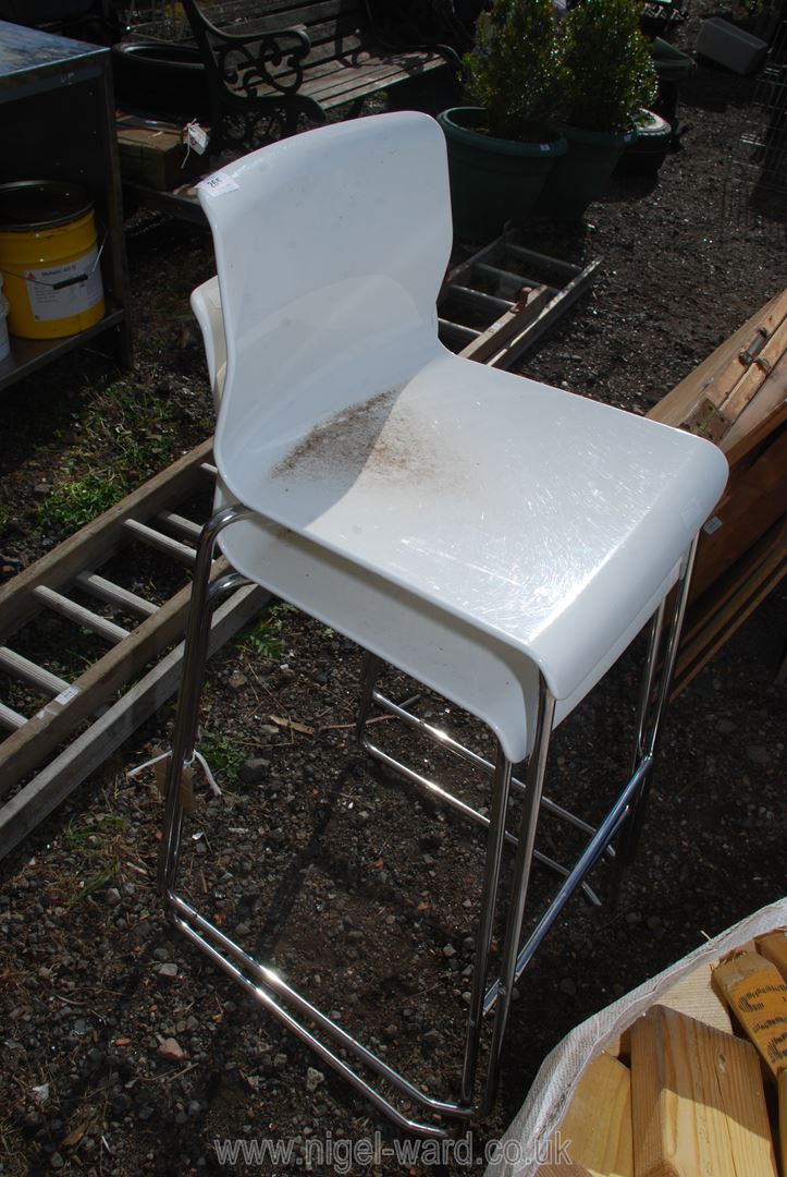 Two Ikea bar stools with white seats.