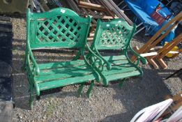 Two wooden slat seated garden chairs with cast iron ends and back inserts.