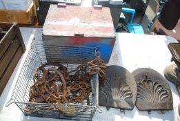 Cow tie chains, cast iron stove lids, and wooden box and contents.