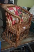 A wicker chair with cushion.