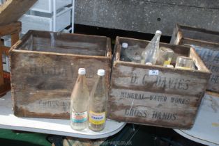 Two wooden ''D.C. Davies'' bottle Crates, one with empty Davies bottles.