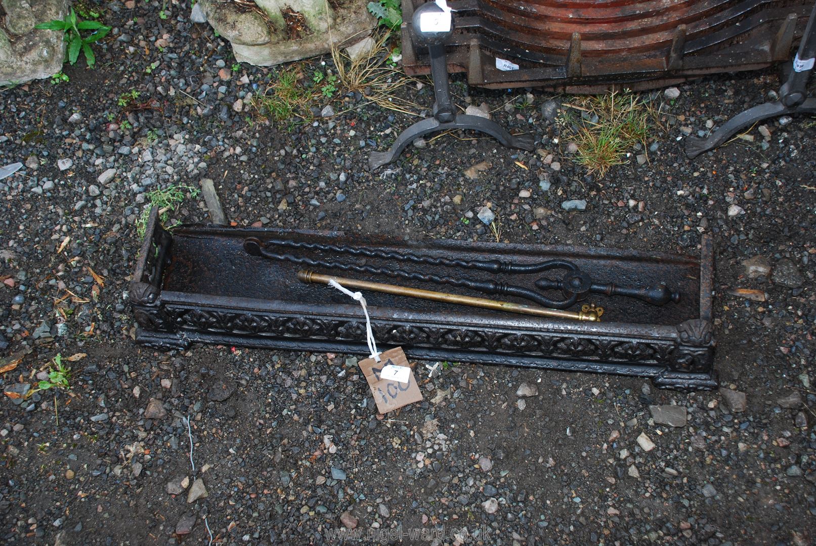 A fire kerb, a fire tongs and a brass swing-action wall mounting towel rail.