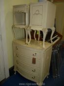 A cream painted chest of drawers and pair of matching beside cabinets,