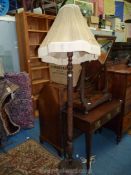 A finely carved hardwood standard lamp with profuse floral/leaf decoration,