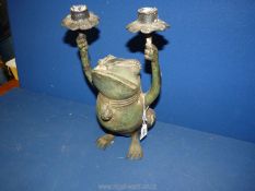 A green metal candle Holder in the form of a frog, 12" tall.