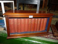 A glazed Mahogany table top display Case, with key, containing eleven Dickens books.