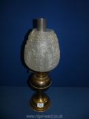 A reproduction brass oil lamp with frosted decorative shade. 21" tall.