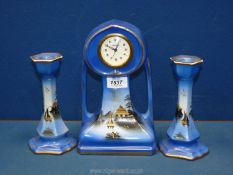 A 'Moonlight' ware 1500 garniture complete with clock and matching candlesticks painted in blue