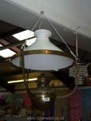 A ceiling hanging Brass framed Oil Lamp complete with milk glass conical shade (no chimney present),