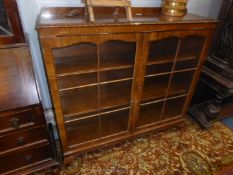 A Mahogany and Walnut floor standing Bookcase having adjustable shelves and a pair of six pane