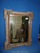 An ornate carved bevelled wall Mirror with gilded detailing, some damage to frame,