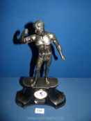 A 'Mercedes' metal Clock surmounted by a figure of a strong man with chains. 14" tall.