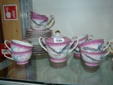 An oriental part teaset in pink and white having gilt rims and handles and hand-painted dragon