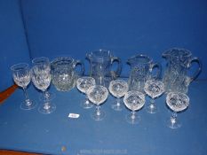 A quantity of glass including four heavy jugs, wine glasses, and six liqueur glasses.