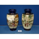 A pair of Japanese vases with scenes of figures in a garden with blossoms,