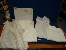 A quantity of christening gowns, one being silk in a A. Sulka box.