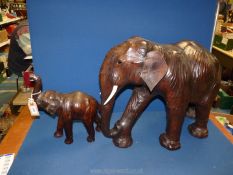 A large leather covered elephant, 20'' tall and a smaller one, 14'' tall, some wear to leather.
