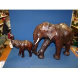 A large leather covered elephant, 20'' tall and a smaller one, 14'' tall, some wear to leather.