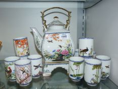 An oriental style teapot on stand with twelve teacups having bird and floral pattern,