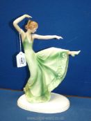 A continental china figure of an Art Deco lady dancing in green dress, possibly German,