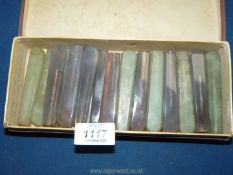 A box of glass knife handles (24) in green and violet/black.
