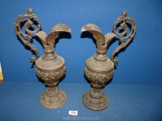 A pair of metal ewers, highly decorated with figures, foliage, and faces, 17".