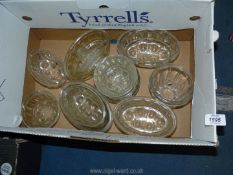 A quantity of glass jelly moulds and a lemon squeezer.