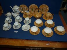 Two part oriental tea sets one with scenes of dragons, both including teapots, cups, and saucers,