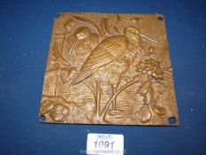 A small well cast bronze plaque depicting storks in a wetland landscape (two storks together