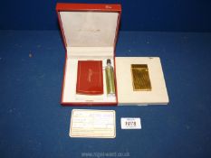 A boxed S.T. Dupont lighter with certificate plus lighter fuel.