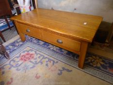 A French light Oak Coffee Table having a pair of short drawers to one side and standing on
