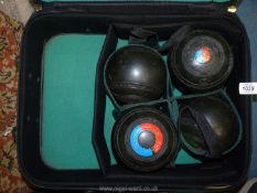 A set of four Almark bowling Balls, for East Monmouthshire, in a green suitcase.