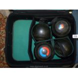 A set of four Almark bowling Balls, for East Monmouthshire, in a green suitcase.