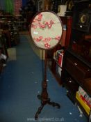 A Mahogany Pole screen (55 1/2" high) with oval panel of silk decorated with flowers,