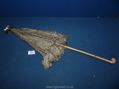 A Victorian black and white stripe silk ladies parasol with tassels, with wooden handle.