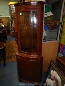A contemporary burrwood finished corner Cabinet on cupboard having serpentine glass door,