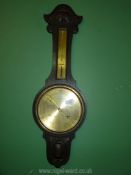 A barometer in dark wood with brass face.