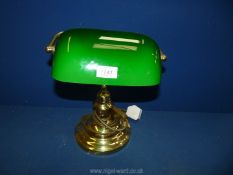 A banker's lamp with green shade.