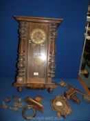 A wall clock with enamel and brass face having Roman numerals, with key and pendulum,