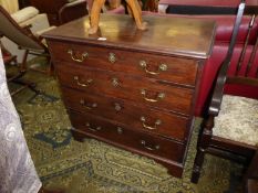 A compact Oak carcassed Georgian Mahogany Chest of four long Drawers standing on bracket feet,