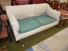 A cream upholstered "Howard & Sons" two/three seater Settee standing on tapering square legs and