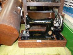 A Singer sewing machine in wooden case, hand operated and including original accessories.