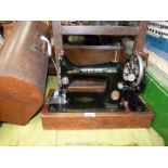 A Singer sewing machine in wooden case, hand operated and including original accessories.